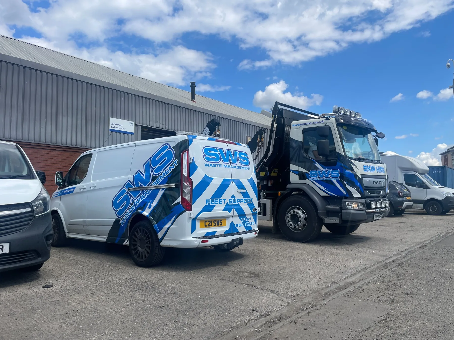 SWS Waste Management fleet support van parked beside an SWS skip lorry